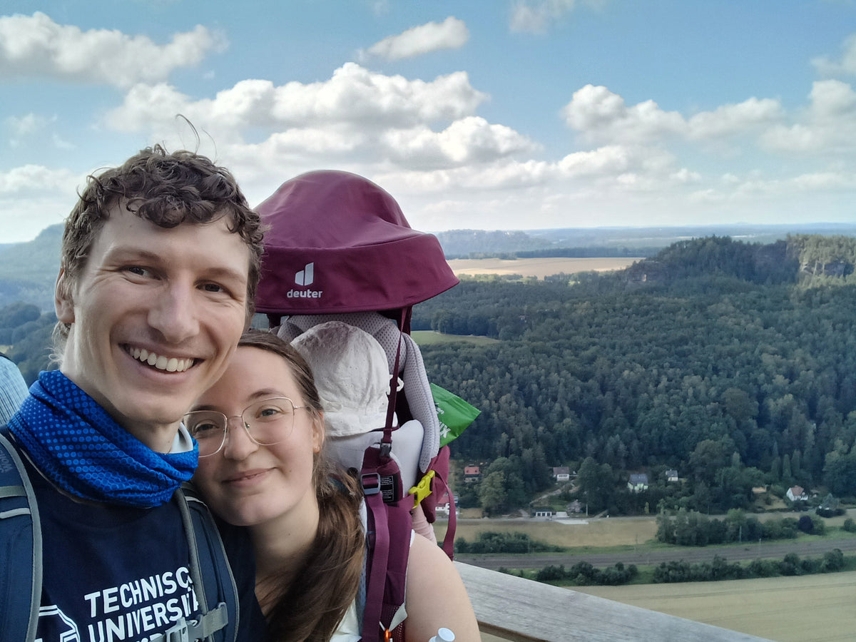 Ben und Anna mit Charlotte in der Kraxe vor der Aussicht in der Sächsischen Schweiz
